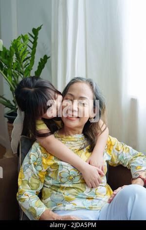 Ritratto asiatico, nonna e nipote che fanno attività di svago e abbraccia per mostrare il loro amore e la cura per gli altri Foto Stock