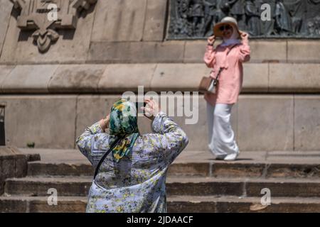 Due turisti sono veduto scattare foto sotto il monumento popolare a Cristoforo Colombo nel porto di Barcellona. Senza Covid, Barcellona è ancora una volta un porto e una destinazione per grandi navi da crociera con migliaia di passeggeri che saturano i servizi e la città. Il governo catalano e il Consiglio comunale di Barcellona hanno adottato misure volte a limitare il numero di crociere al giorno. Foto Stock