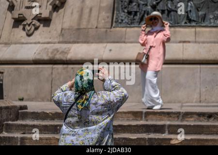 Barcellona, Spagna. 19th giugno 2022. Due turisti sono veduto scattare foto sotto il monumento popolare a Cristoforo Colombo nel porto di Barcellona. Senza Covid, Barcellona è ancora una volta un porto e una destinazione per grandi navi da crociera con migliaia di passeggeri che saturano i servizi e la città. Il governo catalano e il Consiglio comunale di Barcellona hanno adottato misure volte a limitare il numero di crociere al giorno. (Foto di Paco Freire/SOPA Images/Sipa USA) Credit: Sipa USA/Alamy Live News Foto Stock