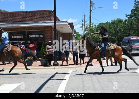 I cowboys afroamericani sfilano a cavallo attraverso Zebulon, NC, come parte di un fine settimana di celebrazione giunettesimo di emancipazione dalla schiavitù. Foto Stock