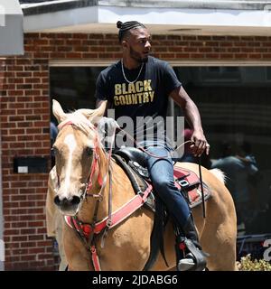 I cowboys afroamericani sfilano a cavallo attraverso Zebulon, NC, come parte di un fine settimana di celebrazione giunettesimo di emancipazione dalla schiavitù. Foto Stock