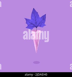 Brillante foglia di acero autunnale in un cono gelato a cialda, concetto di stagione. Foto Stock