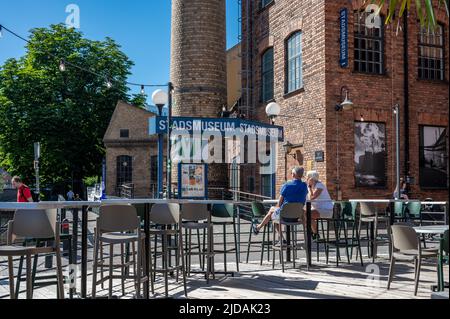 Vista da un ristorante all'aperto verso il museo della città e Holmbrogränd è un vicolo storico attraverso il paesaggio industriale di Norrköping. Foto Stock