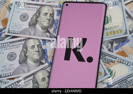 Logo dell'app Klarna visto sullo schermo dello smartphone piazzato su bollette in dollari. Concetto per l'app di credito. Stafford, Regno Unito, giugno 19 2022 Foto Stock