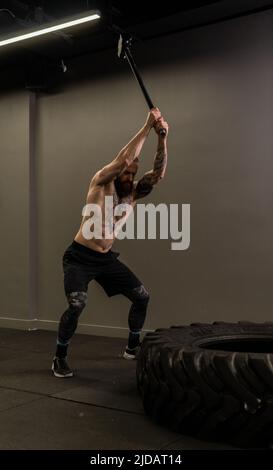 Mazza pneumatico ruota camion donna sostituire palestra martello giovane, per la concentrazione di attrezzature da maschio da allenamento muscolare, uomo adulto Foto Stock