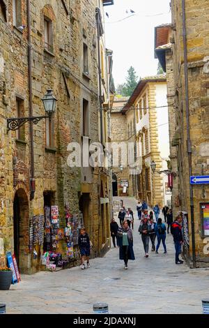 Persone che camminano per le strette stradine della vecchia città collinare, vie dei Marchesi, Volterra, Toscana, Italia. Foto Stock