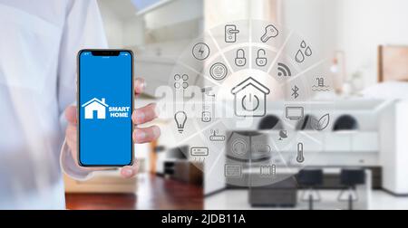 Man Hand show smartphone smart home GUI controlla ogni stanza della casa. Utilizzare l'assistente di automazione domestica intelligente con schermo intelligente su uno schermo virtuale e un Foto Stock