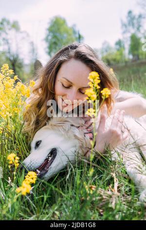 Giovane bella donna e il suo cane Golden Retriever divertirsi in estate Foto Stock