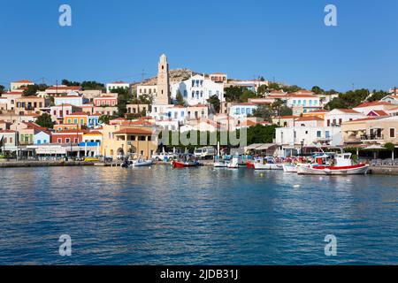 Edifici tradizionali e barche ormeggiate lungo il lungomare nel porto di Emborio, la città principale sull'isola di Halki (Chalki) Foto Stock