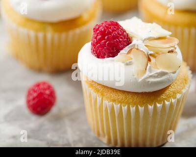 Dessert leggero e delizioso - muffin con crema proteica, lamponi e mandorle su sfondo bianco. Primo piano. Ristorante, hotel, panetteria, supermercato. Foto Stock