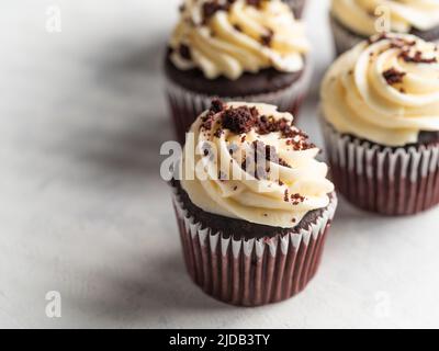 Dessert americano tradizionale - muffin al cioccolato con crema di caffè e cioccolato grattugiato. Isolato su sfondo bianco. Pasticceria, caffè, re Foto Stock