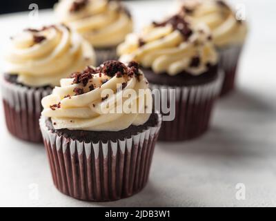 Muffin al cioccolato con crema di burro guarnito con cioccolato grattugiato. Isolato su sfondo bianco. Sfondo alimentare. Vacanza, delizia per gli ospiti, deliciou Foto Stock