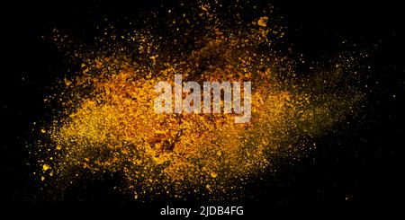 Esplosione, schizzi di curcuma su sfondo nero. India Seasoning. La polvere arancione della radice curmerica. Foto Stock