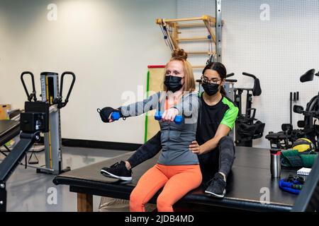 Una donna paraplegica che fa bilaterale cresce durante il suo allenamento con il suo allenatore: Edmonton, Alberta, Canada Foto Stock