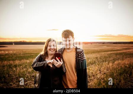 Una mamma con epilessia che prende un selfie con suo figlio che ha la sindrome di Asperberger in un campo in una fattoria dopo il raccolto: Westlock, Alberta, Canada