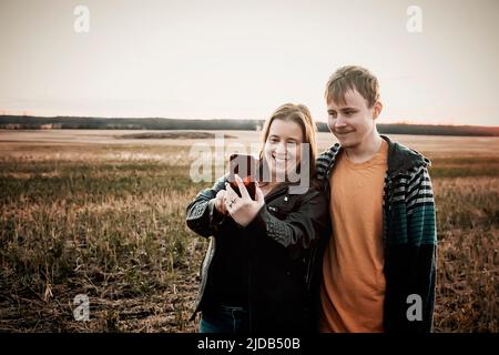 Una mamma con epilessia che prende un selfie con suo figlio che ha la sindrome di Asperberger in un campo in una fattoria dopo il raccolto: Westlock, Alberta, Canada
