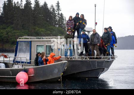 Gli amici e la famiglia di una persona morta la ricordano nel suo luogo di pesca preferito a Kachemak Bay durante un memoriale sull'acqua vicino a Homer, Alaska Foto Stock