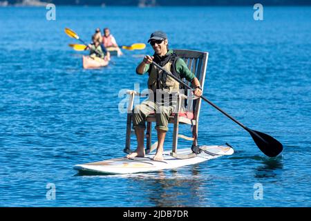 La guida di Tutka Bay Lodge ha indossato una sedia a dondolo sulla sua tavola da surf in piedi per trasformarla in una tavola da sedersi Foto Stock