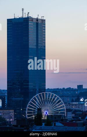 Vista del Tour du Midi al crepuscolo con, ai suoi piedi, la ruota panoramica della fiera Midi. Bruxelles Foto Stock