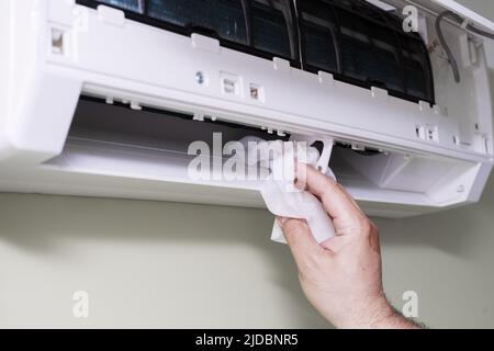 pulizia di un filtro aria condizionata sporco e polveroso in casa. maschio rimozione di un filtro aria condizionata polveroso. Foto Stock