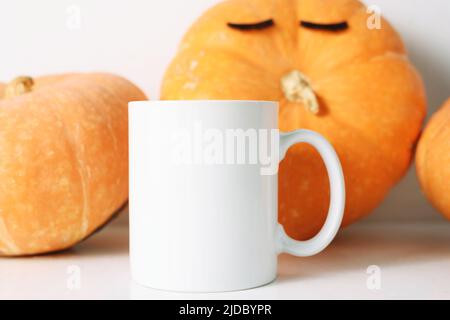 Tazza di caffè bianca e molti pomprini caduta mockup. Foto Stock