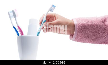 Donna che prende il suo spazzolino iIsolated su sfondo bianco, sta pulendo i suoi denti, concetto di igiene orale Foto Stock