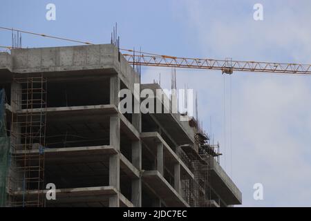 Costruzione del nuovo edificio con gru sul sito di costruzione. Gru e cantiere contro il cielo Foto Stock