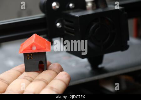 3D casa modello stampato con una vera stampante 3D sul suo sfondo che esegue circa 3D opere di stampa Foto Stock