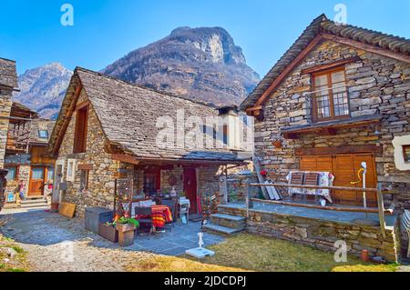 Il piccolo cortile di fronte alle tradizionali case in pietra nel villaggio di Sonogno, Valle Verzasca, Svizzera Foto Stock