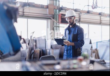 Responsabile tecnico che esegue il controllo di routine in fabbrica industriale Foto Stock