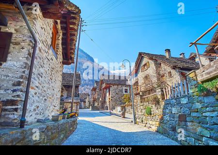 Il vicolo in paese con vecchie case in pietra alpina, sormontato da tetti in pietra, Sonogno, Valle Verzasca, Svizzera Foto Stock