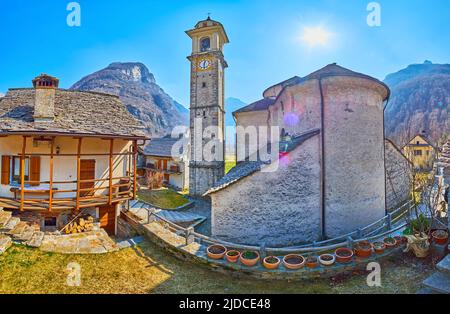 Panorama della vecchia strada con torre di orologio della Chiesa di Santa Maria Lauretana, case di paese e le Alpi sullo sfondo, Sonogno, Valle Verzasca, Svizzera Foto Stock