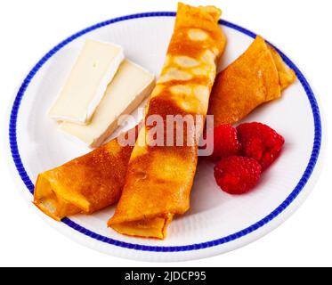 Pancake con miele, lamponi e fette di formaggio Foto Stock