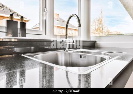 Frigorifero moderno con comoda presa per bevande, situato nella cucina moderna e luminosa di casa Foto Stock