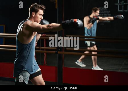Giovane uomo muscoloso che si allena in palestra Foto Stock