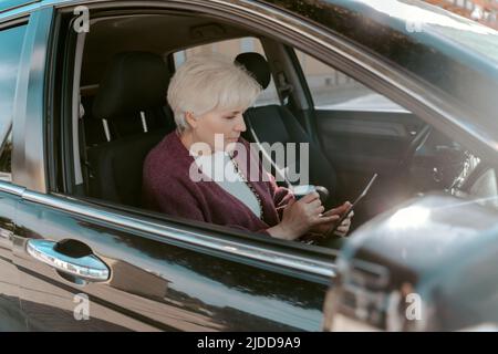 Passeggero femminile seduto da solo nell'automobile Foto Stock