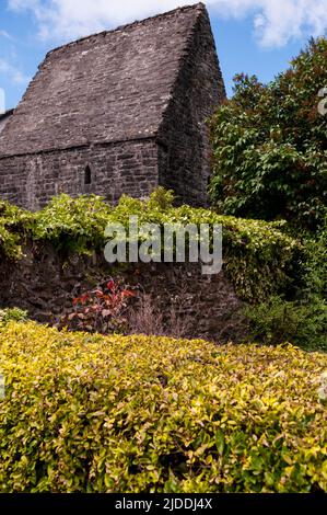 Piccola finestra ad arco appuntita e ripido tetto a falde di pietra dell'Oratorio di St. Colmcille House a Kells, in Irlanda, un importante insediamento monastico. Foto Stock