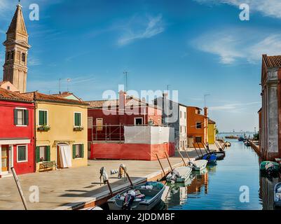 La luce del sole illumina un lato di un canale nella città di Burano nel porto di Venezia. Foto Stock