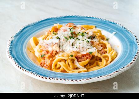 Tagliatelle fatte in casa con salsa di crema di pomodoro e parmigiano. Pronto a mangiare. Foto Stock