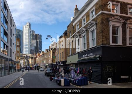 Wentworth Street, Spitalfields, la moderna sede del Petticoat Lane Market, in una giornata non di mercato. Città di Londra sfondo. Foto Stock