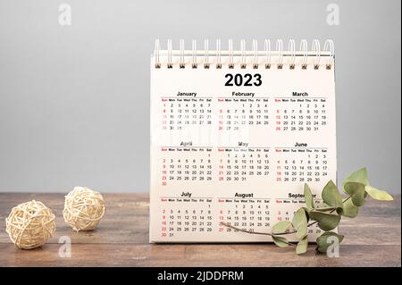 Calendario anno 2023 programma. 2023 blocco appunti su tavolo in legno con calandra e sfondo grigio. Nuovo anno. Piani per il 2023. Sfondo grigio Foto Stock