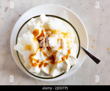 Dessert francese - isola galleggiante servita in una ciotola di vetro Foto Stock