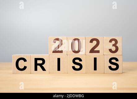 Concetto di gestione delle crisi nel nuovo anno 2023 . Cubi di legno 2023 con crisi di testo. Crisi economica, fallimento e crisi finanziaria. Foto Stock