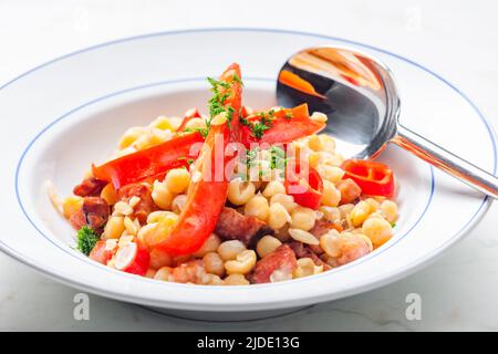 miscela di piselli gialli e pancetta servita con pepe rosso e peperoncino Foto Stock