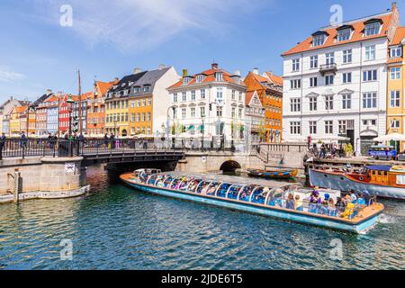Un tour turistico in barca che passa Nyhavn, il colorato lungomare del canale del 17th secolo a Copenhagen, Danimarca. Foto Stock