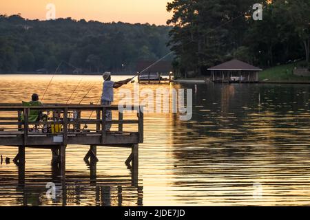 Pesca in coppia da un molo di pesca al tramonto sul lago Oliver, un serbatoio sopra la diga di Oliver tra Columbus, Georgia e Phenix City, Alabama. (USA) Foto Stock