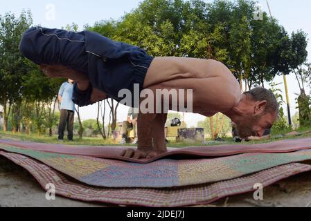 Lahore, Punjab, Pakistan. 20th giugno 2022. Persone pakistane che svolgono una sessione di yoga in un terreno alla vigilia della Giornata Internazionale dello Yoga a Lahore. Milioni di persone in tutto il mondo hanno partecipato alla Sesta Giornata Internazionale dello Yoga. La Giornata Internazionale dello Yoga, o comunemente e non ufficialmente chiamata Giornata dello Yoga, viene celebrata ogni anno il 21 giugno dal suo inizio nel 2015. Una giornata internazionale per lo yoga è stata dichiarata all'unanimità dall'Assemblea Generale delle Nazioni Unite (Credit Image: © Rana Sajid Hussain/Pacific Press via ZUMA Press Wire) Foto Stock