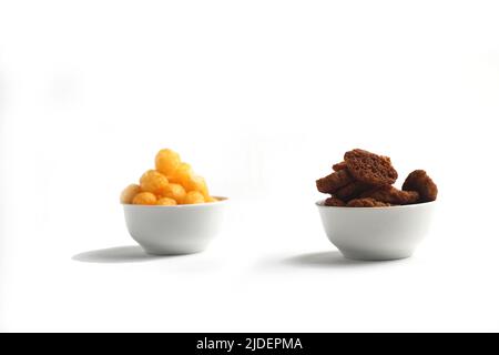 concetto di cibo malsano - ciotole di formaggio a palla soffiato patatine di mais e pane al forno isolato su sfondo bianco. L'immagine contiene spazio per la copia Foto Stock