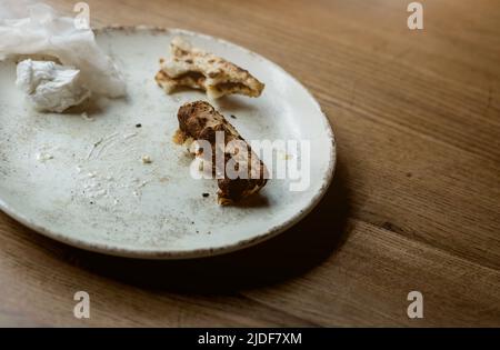 Rifiuti alimentari, pezzo di pizza rimane sul piatto dopo cena Foto Stock