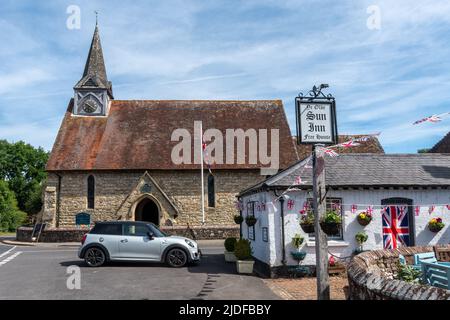 Plaistow villaggio nel Sussex occidentale, Inghilterra, Regno Unito. Vista del centro del paese con la Chiesa della Santissima Trinità e il pub Sun Inn Foto Stock